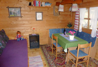 Cozy living area in Chalet Steingaden, Germany, featuring wood paneling, dining table, and country decor.