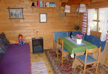Accogliente area soggiorno nel chalet Steingaden, Germania, con tavolo da pranzo e decorazioni rustiche.