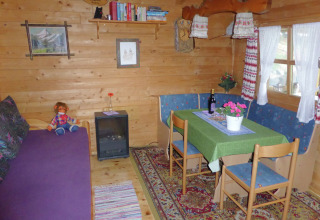 Cozy living area in Chalet Steingaden, Germany, featuring wood paneling, dining table, and country decor.