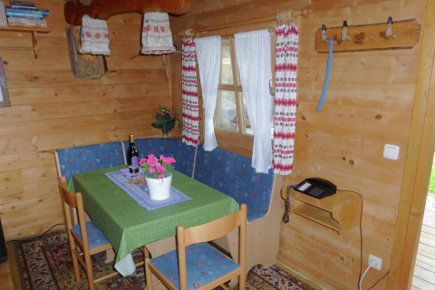 Cozy dining area in Steingaden chalet, Germany, with a green tablecloth and wooden interior.