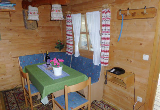 Cozy dining area in Steingaden chalet, Germany, with a green tablecloth and wooden interior.