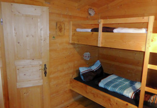 Wooden room with bunk beds in Chalet Steingaden, Germany, cozy interior and warm natural lighting.