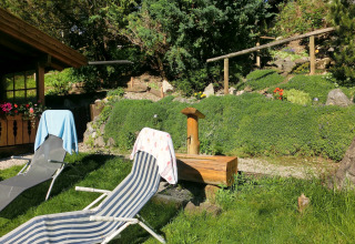 Outdoor area at chalet Steingaden in Germany with deck chairs, towels, and a lush green garden.