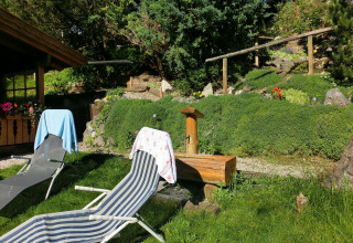 Outdoor area at chalet Steingaden in Germany with deck chairs, towels, and a lush green garden.