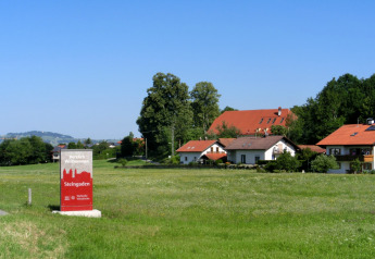 Chalet Steingaden in Germania, case accoglienti dai tetti rossi circondate da campi verdi sotto il cielo blu.