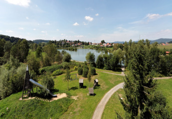Aerial view of Holiday park «Jägerwiesen 1» in Germany showing a playground, lake and greenery.