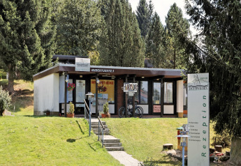 Receptionen ved ferieparken Jägerwiesen 1 i Tyskland omgivet af grønne træer og hyggelig natur.