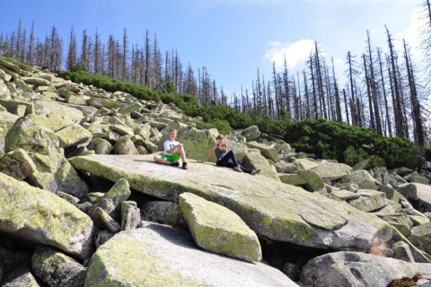 Two people sitting on large rocks at Holiday Park Jägerwiesen 1, Germany, with trees in the background.
