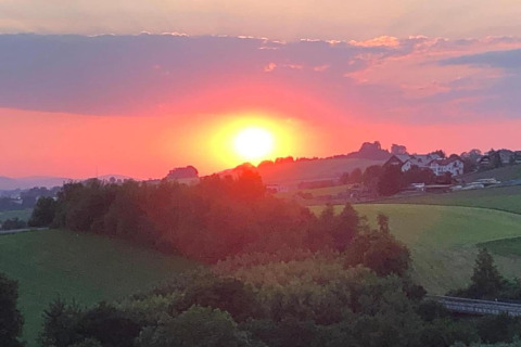 Tramonto su un paesaggio verde visto da Holiday park «Jägerwiesen 1» in Germania, con case in lontananza.