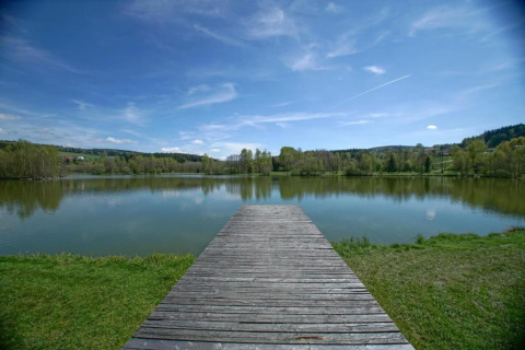 Un molo di legno si affaccia su un lago tranquillo presso Holiday park «Jägerwiesen 1» in Germania.