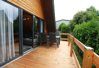 Houten terras met buiten eetset bij Type A1 - Nurdachhaus lodge in Duitsland, omgeven door groen.