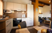 Cucina moderna e zona pranzo in uno chalet del villaggio Holiday Öfingen, Germania, ambiente accogliente e luminoso.