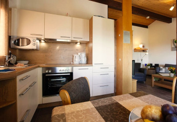Cuisine moderne avec coin repas dans un chalet du Holiday village Öfingen en Allemagne, ambiance chaleureuse.