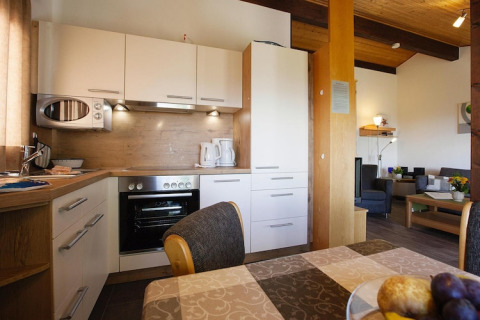 Cucina moderna e zona pranzo in uno chalet del villaggio Holiday Öfingen, Germania, ambiente accogliente e luminoso.