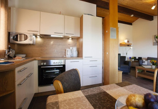 Modern kitchen and dining area in a Holiday village Öfingen chalet in Germany, with cozy and bright interior.