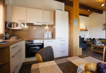 Modern kitchen and dining area in a Holiday village Öfingen chalet in Germany, with cozy and bright interior.