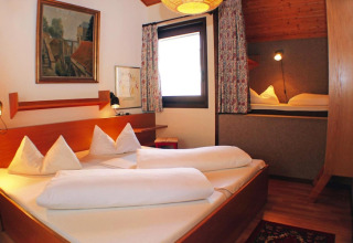 Bright chalet bedroom at Holiday village Öfingen, Germany, with double bed and cozy children’s alcove.