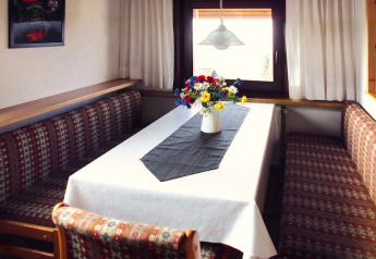 Eethoek in chalet Holiday village Öfingen - 68 m² Type C Sioux met bloemen op tafel in Duitsland.