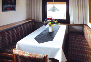 Coin repas au chalet Holiday village Öfingen - 68 m² Type C Sioux avec fleurs sur la table en Allemagne.