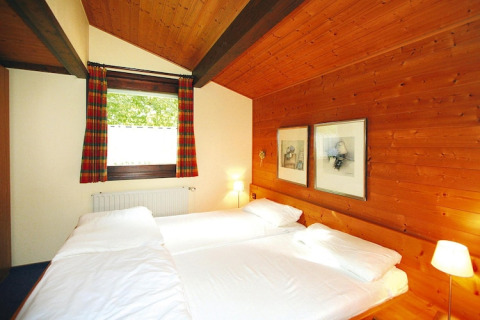 Camera da letto con pareti in legno e due letti al villaggio Öfingen, 68 mq, Tipo C Sioux, Germania