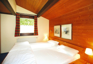 Camera da letto con pareti in legno e due letti al villaggio Öfingen, 68 mq, Tipo C Sioux, Germania