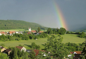 Rainbow over hills, fields, and village, photographed from Holiday village «Öfingen - 68 sqm Type C Sioux» in Germany.