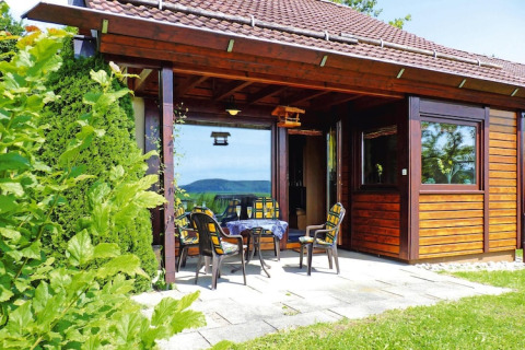 Acogedor chalet de madera en Holiday village Öfingen, Alemania, con patio, sillas de jardín y vistas.