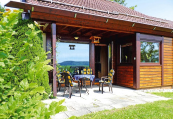 Sfeervol houten chalet in vakantiepark Öfingen, Duitsland, met terras, tuinmeubilair en uitzicht.
