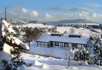 Chalet innevato e paesaggio di villaggio pittoresco al Holiday village Öfingen, Germania, in inverno.