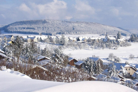 Paysage enneigé avec chalets et collines dans le village vacances Öfingen, Allemagne, en hiver.