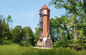 Sfeervol toren-chalet genaamd 'Water tower 75 sqm', omgeven door bomen in Duitsland.