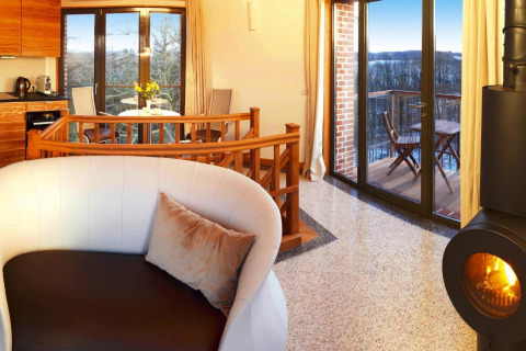 Cozy chalet interior at 'Water tower 75 sqm' in Germany, featuring fireplace, balcony, and scenic views.