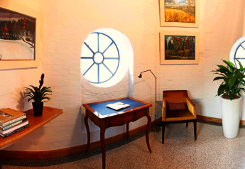 Gezellig hoekje in chalet Water tower 75 sqm in Duitsland met ronde ramen, planten en schilderijen.