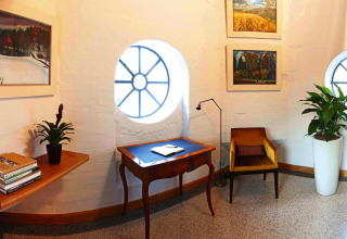 Knus hoekje in chalet Water tower 75 sqm in Duitsland met ronde ramen, planten en schilderijen.