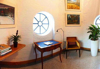 Knus hoekje in chalet Water tower 75 sqm in Duitsland met ronde ramen, planten en schilderijen.