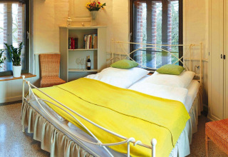 Cozy bedroom in chalet 'Water tower 75 sqm' in Germany featuring a double bed and bright decor.