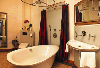 Luxury bathroom at Water Tower 75 sqm chalet in Germany featuring a freestanding tub and large shower.