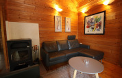 Cozy living room in Holiday home Svenja Wiefelstede-Lehe, Germany, with leather sofa and wood walls.