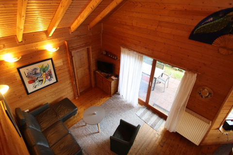 Woonkamer vanuit bovenaanzicht bij Holiday home Svenja Wiefelstede-Lehe, met houten muren en grote ramen.