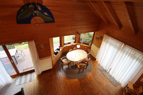Bovenzicht op de eetruimte in Holiday home Svenja Wiefelstede-Lehe in Duitsland met houten interieur en grote ramen.