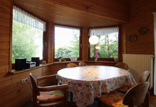Comedor rústico con paredes de madera y ventanales al bosque en Holiday home Svenja Wiefelstede-Lehe.