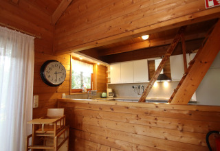 Houten keuken en eetruimte in Holiday home Svenja Wiefelstede-Lehe, Duitsland, met klok aan de wand.