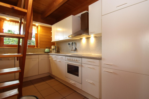 Moderne witte keuken met houten plafond en trap in Holiday home Svenja Wiefelstede-Lehe, Duitsland.