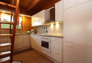Moderne witte keuken met houten plafond en trap in Holiday home Svenja Wiefelstede-Lehe, Duitsland.