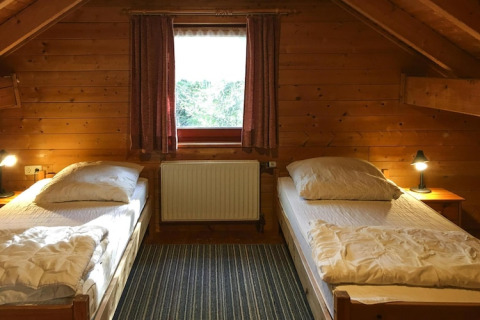 Cozy twin bedroom with wood-paneled walls at Holiday home Svenja Wiefelstede-Lehe, Germany.