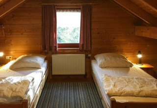 Tweepersoonskamer met houten lambrisering in Holiday home Svenja Wiefelstede-Lehe, Duitsland.