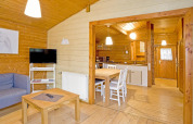 Interior de madera de la cabaña Type C House 363 364 361 362 en Alemania con cocina, mesa y sofá.