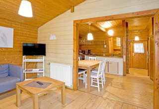 Houten interieur van Type C House 363 364 361 362 lodge in Duitsland met keuken, eettafel en bank.