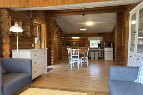 Lichte en gezellige hutinterieur met houten balken, eethoek en open keuken in een lodge in Duitsland.