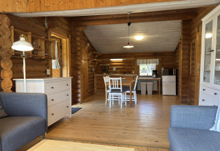 Lichte en gezellige hutinterieur met houten balken, eethoek en open keuken in een lodge in Duitsland.